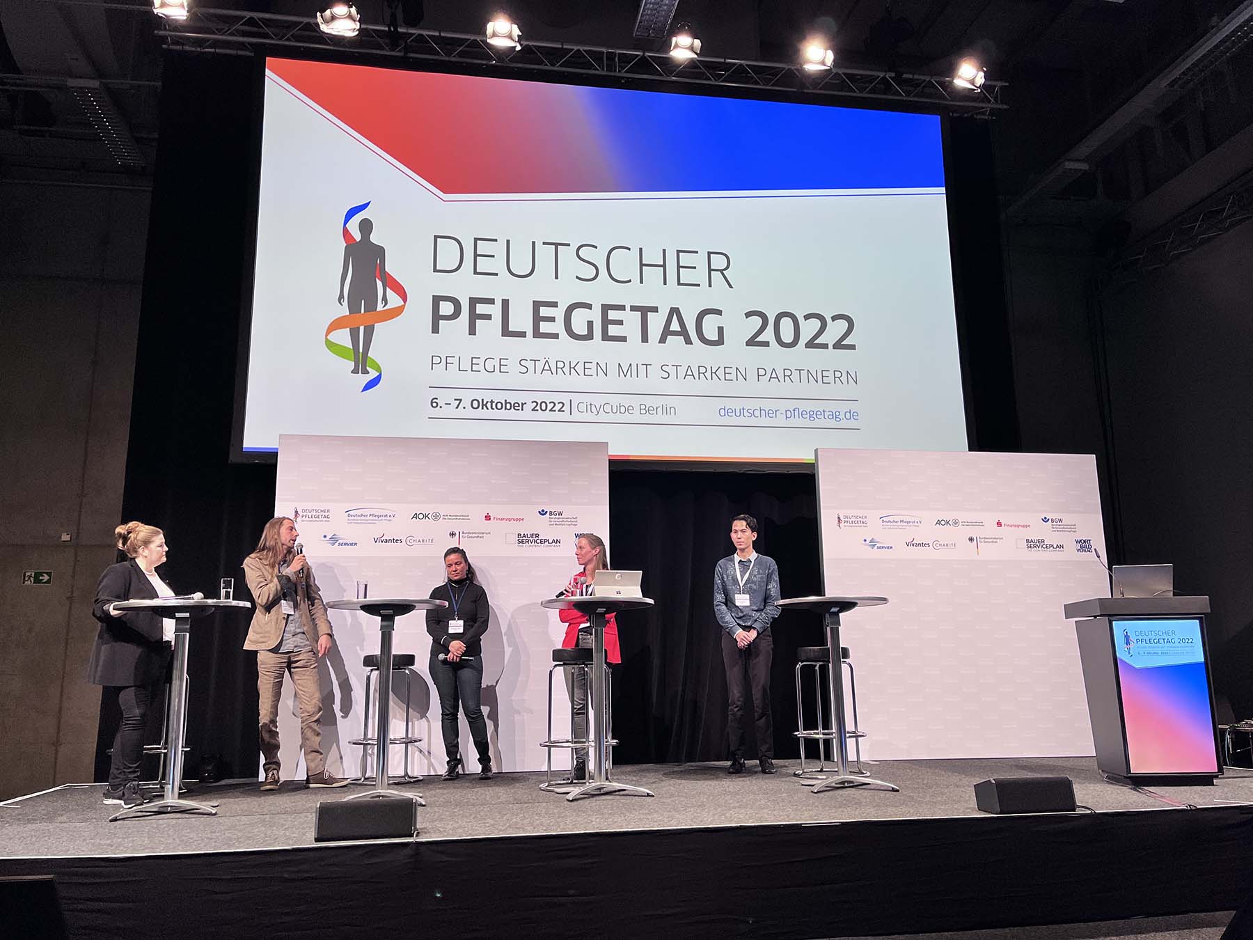 Foto einer Podiumsdiskussion mit mehreren Teilnehmenden beim Deutschen Pflegetag 2022